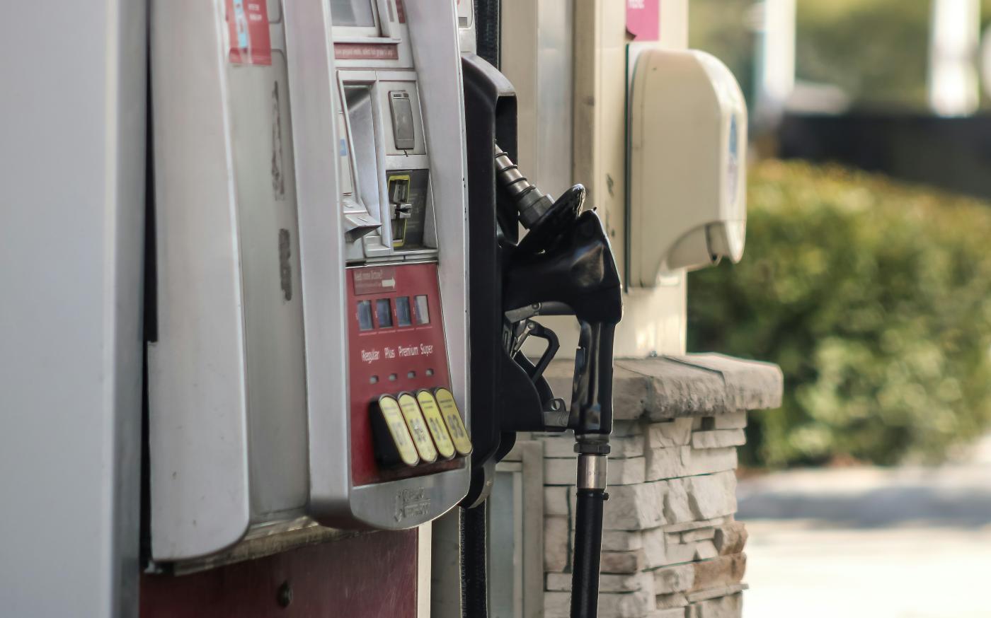a gas pump next to a brick wall by Dawn McDonald courtesy of Unsplash.
