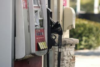 a gas pump next to a brick wall by Dawn McDonald courtesy of Unsplash.