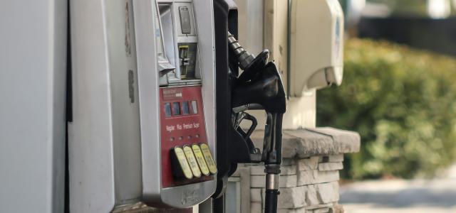 a gas pump next to a brick wall by Dawn McDonald courtesy of Unsplash.